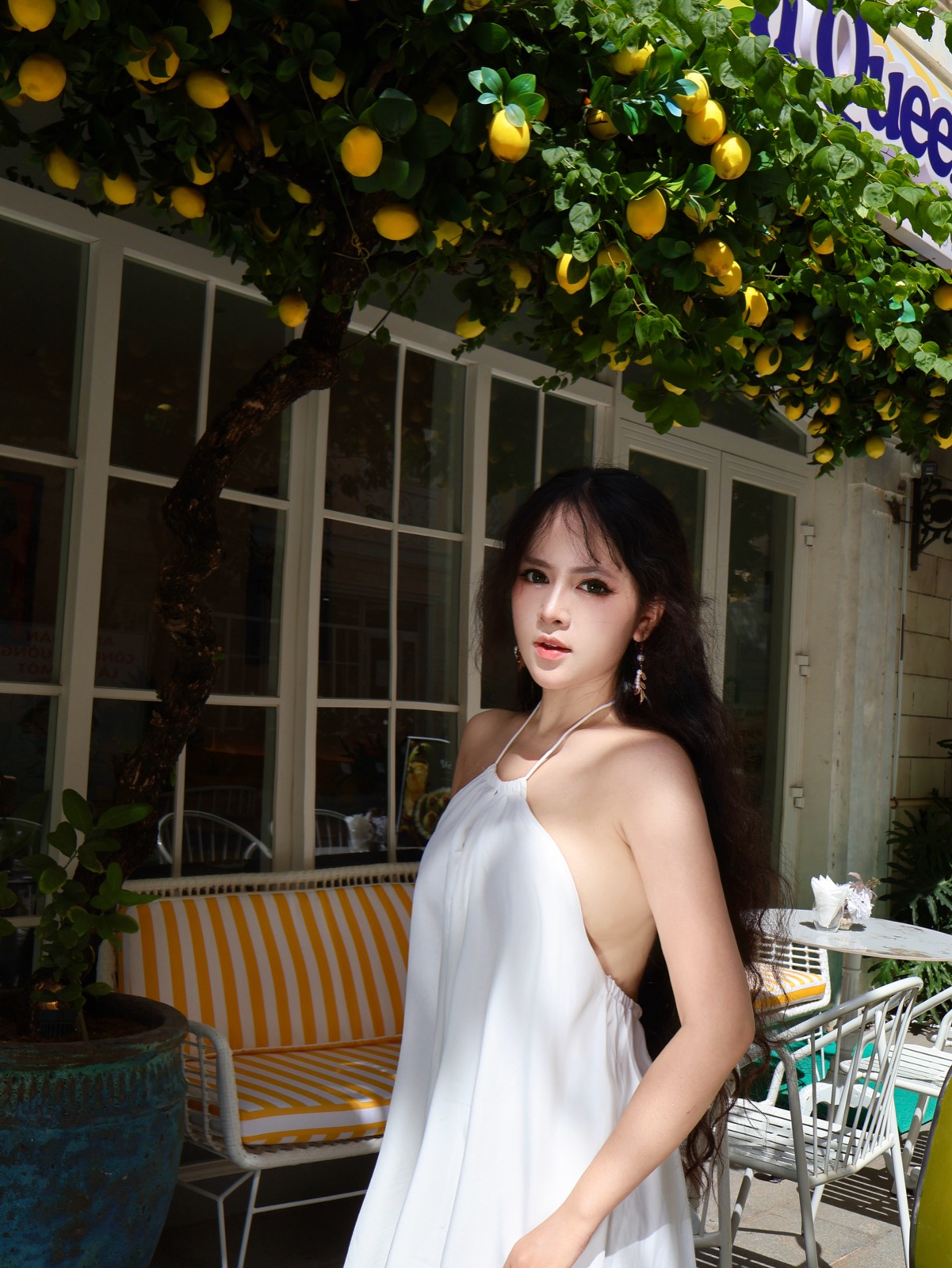 Clara in white beneath a lemon tree