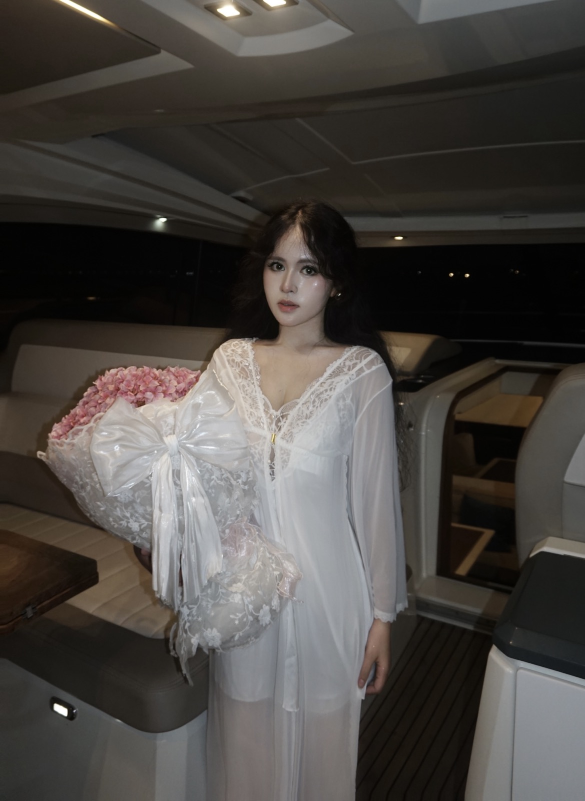 Clara in white with flowers aboard a yacht