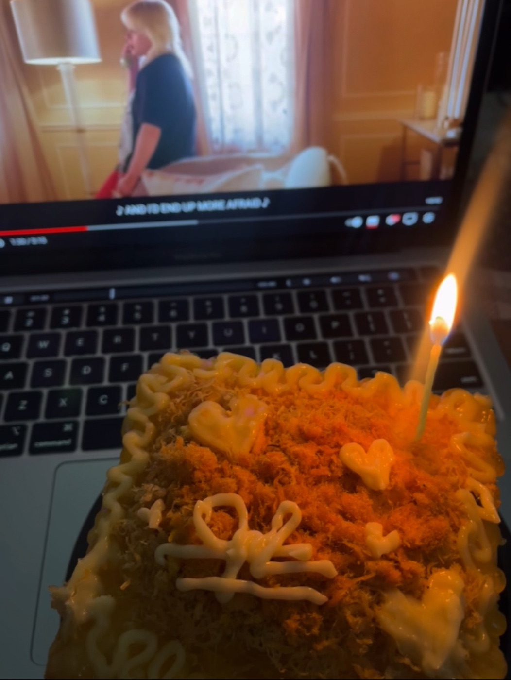 A homemade celebration cake beside a laptop
