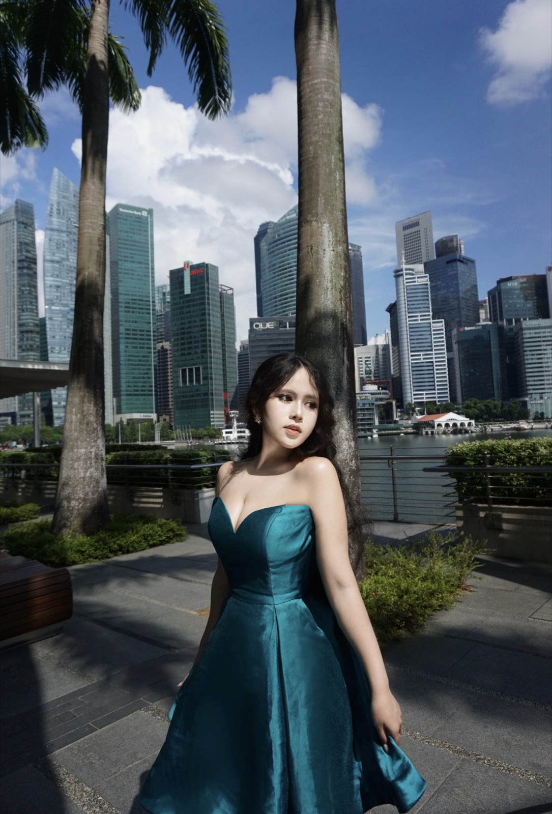 Clara in an emerald dress beside the Singapore skyline